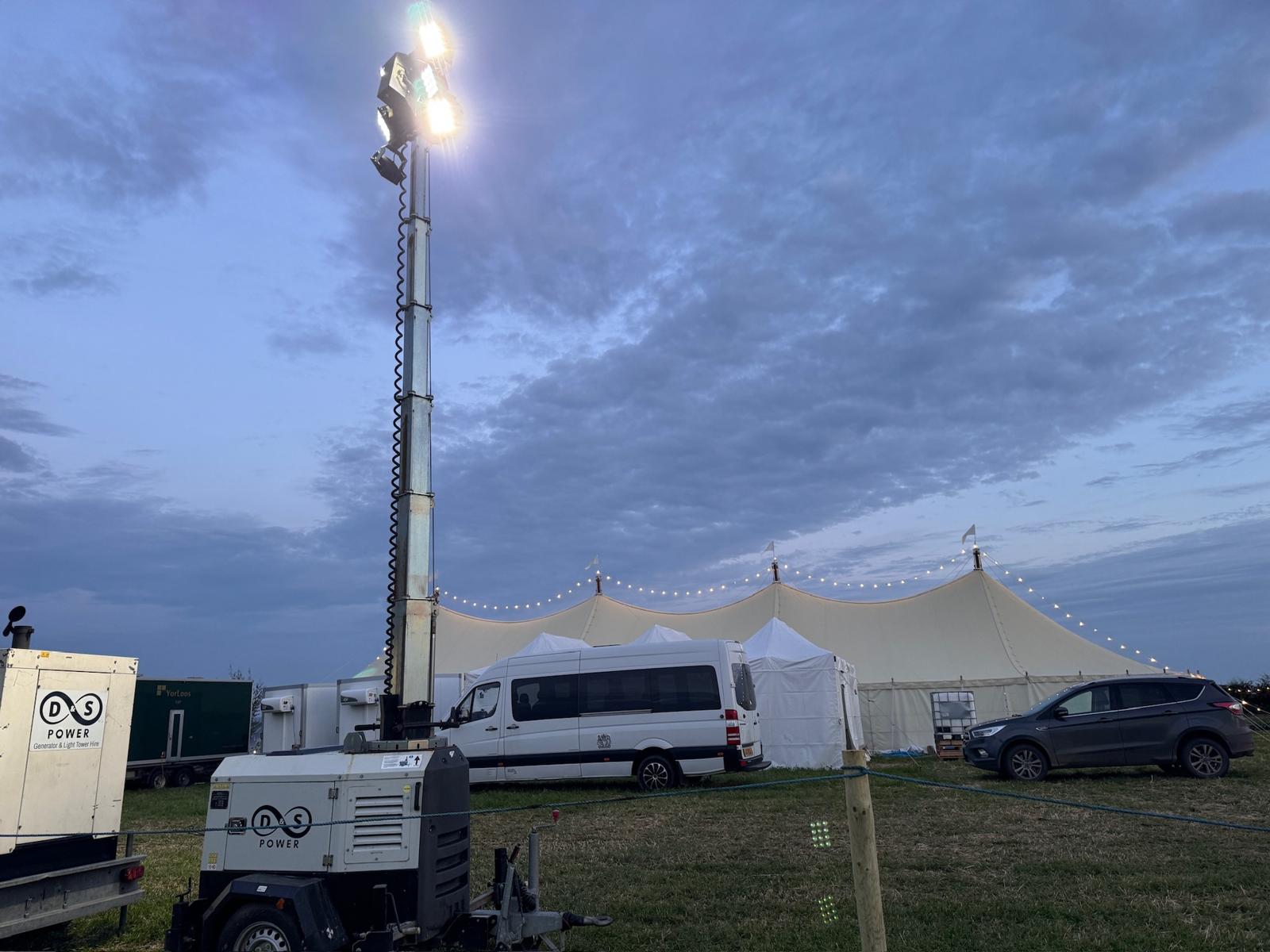 D&S Power generator and raised light tower beside an event marquee at dusk